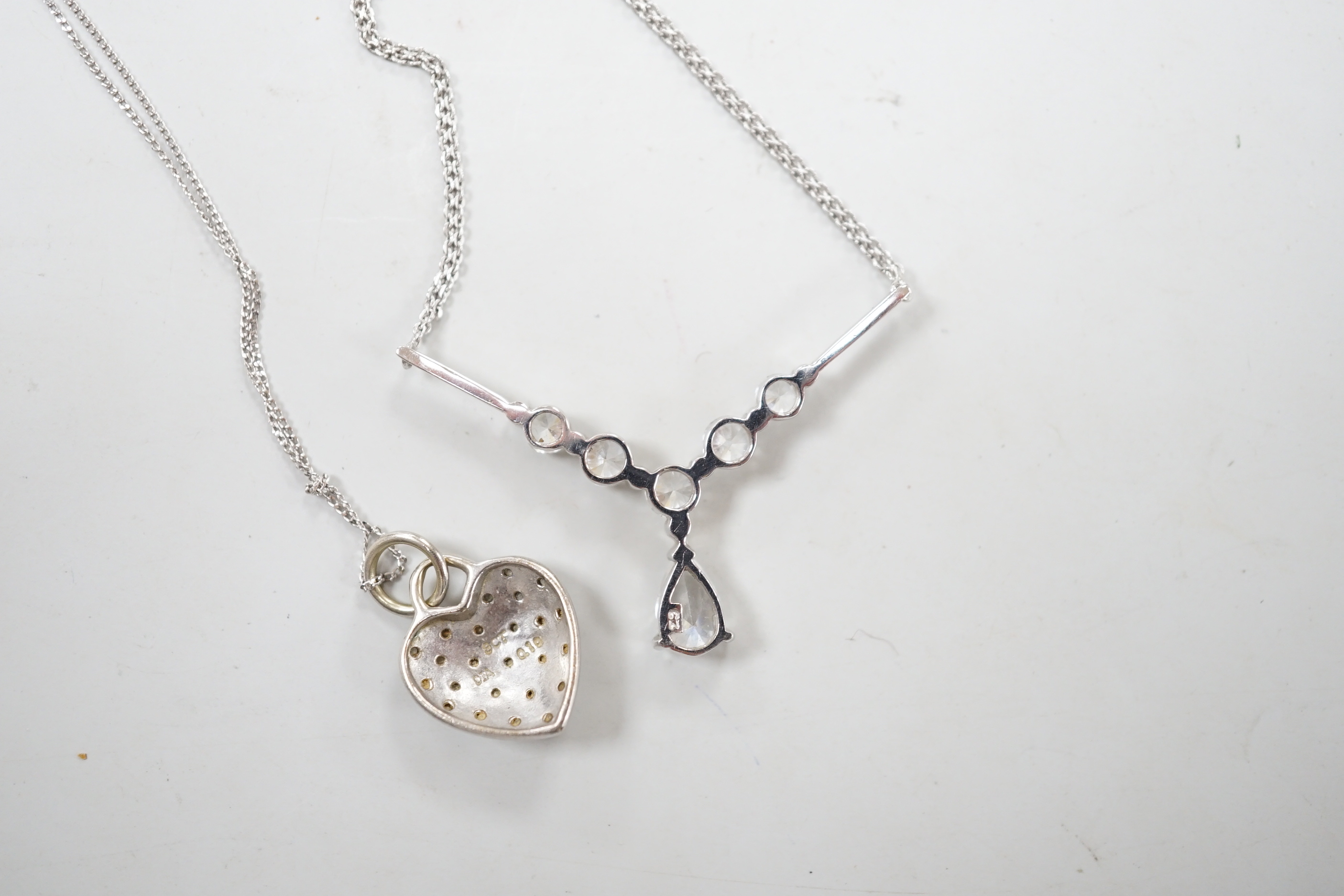 Two modern white metal (stamped 375) and gem set pendant necklaces, including a diamond chip set heart, longest 50cm